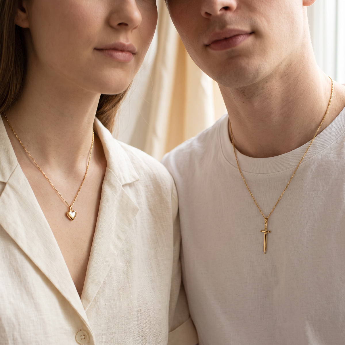 Couple wearing the heart and sword necklaces