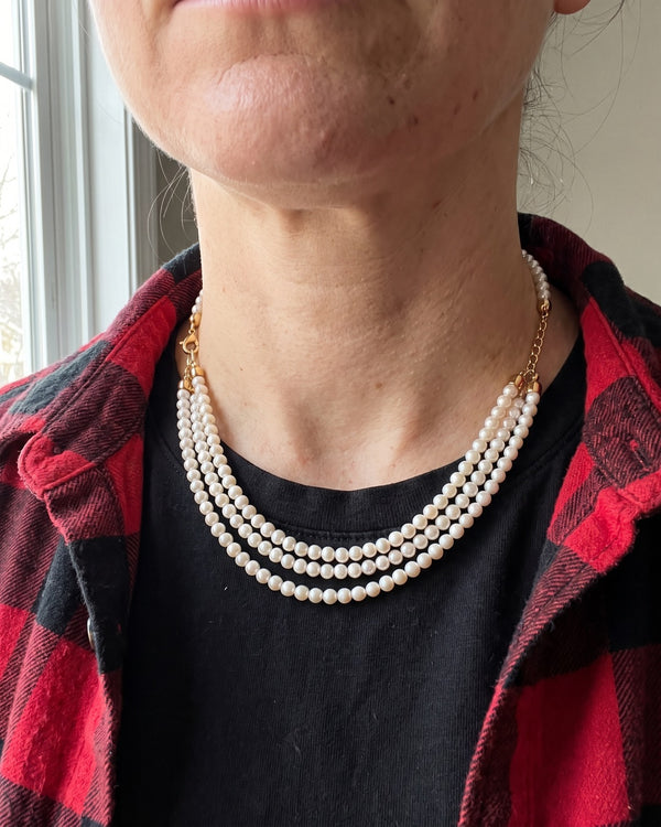 Layered pearl necklace worn with a black t-shirt